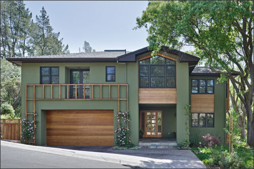Dark sage green house with Wooden Trim and car parking in front and Wooden door