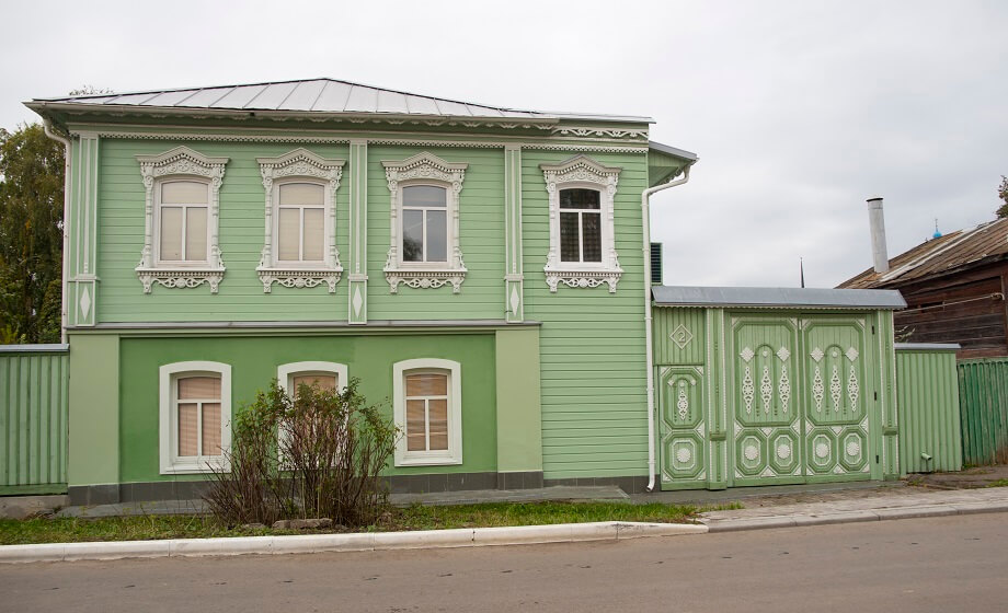 sage green house with white and green trim and white window and regular rooftop