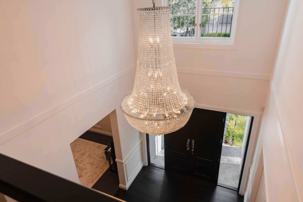 A luxurious crystal chandelier hangs in the foyer of a home